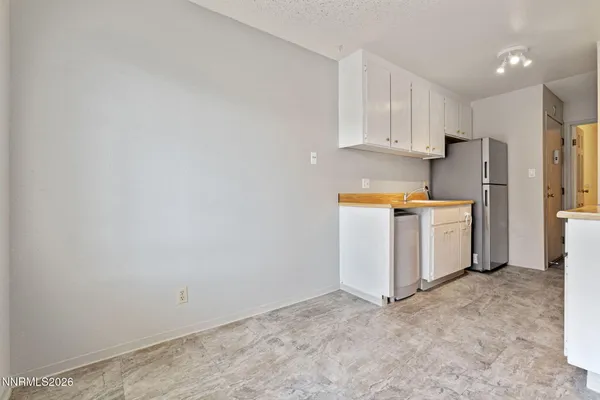 a kitchen with stainless steel appliances a refrigerator and white cabinets