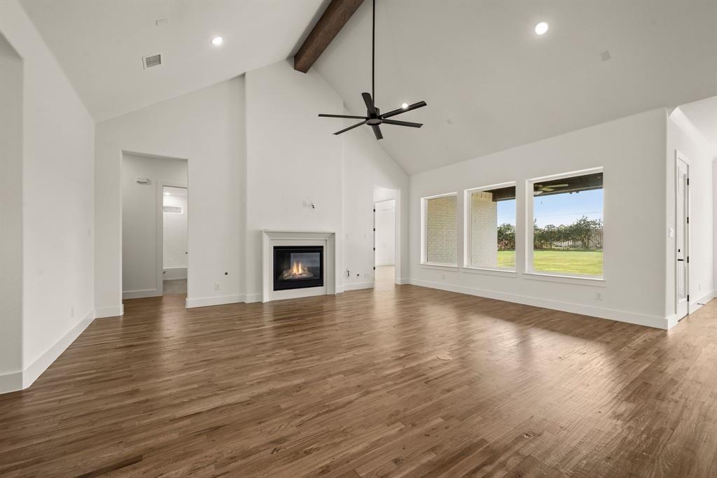 149 Highgate Court Boyd, TX 76023 - Photo 9 of 40 an empty room with wooden floor fireplace and windows