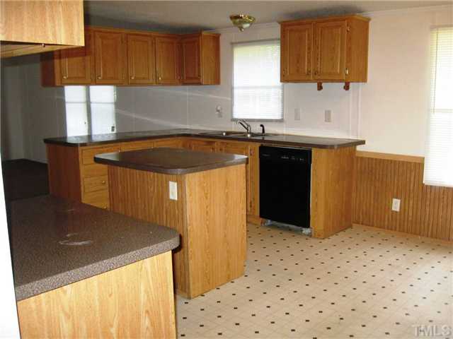 246 Skeet Range Road Coats, NC 27521 - Photo 5 of 20 a kitchen with granite countertop a sink a stove and a refrigerator