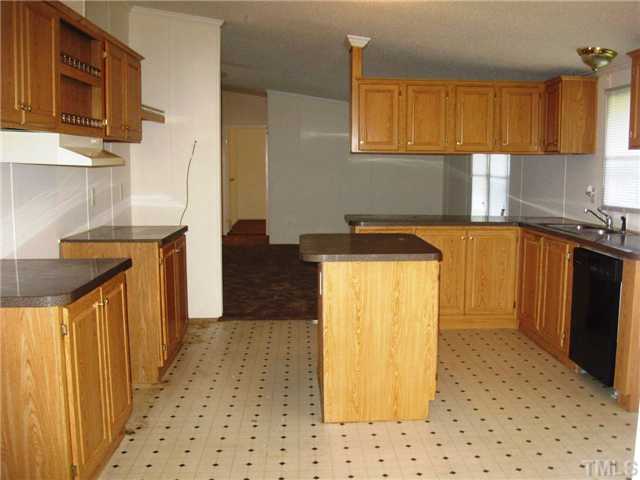 246 Skeet Range Road Coats, NC 27521 - Photo 6 of 20 a kitchen with a sink a stove top oven cabinets and a refrigerator