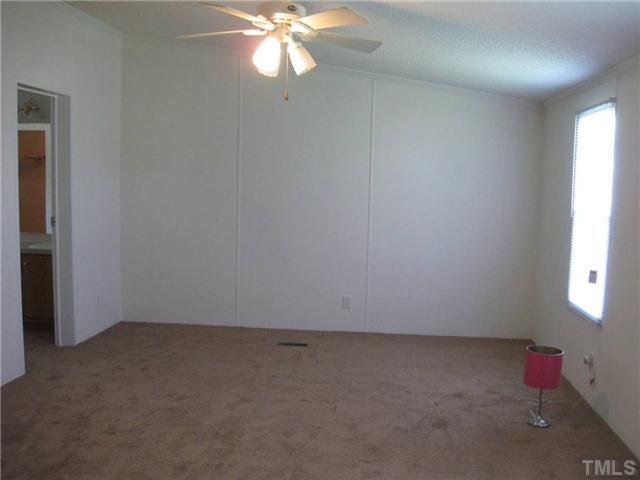246 Skeet Range Road Coats, NC 27521 - Photo 10 of 20 an empty room with a chandelier fan and windows