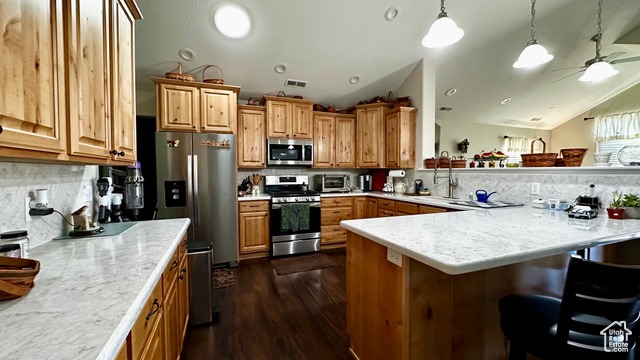 929 West 1920 South, Unit A Syracuse, UT 84075 - Photo 21 of 26 Kitchen featuring lofted ceiling, stainless steel appliances, a kitchen breakfast bar, decorative backsplash, and decorative light fixtures