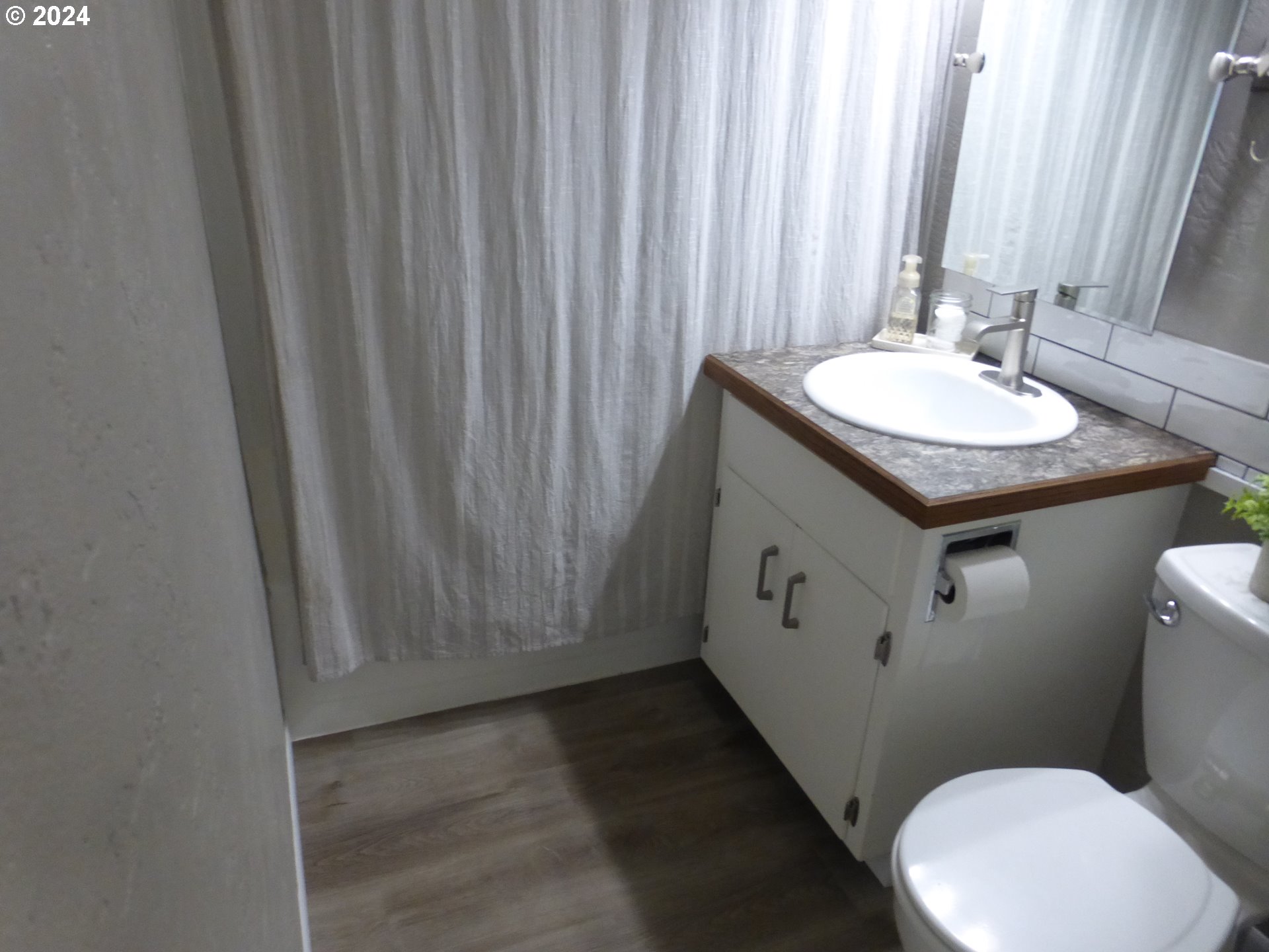 1026 M Street Springfield, OR 97477 - Photo 13 of 20 a bathroom with a toilet sink and mirror