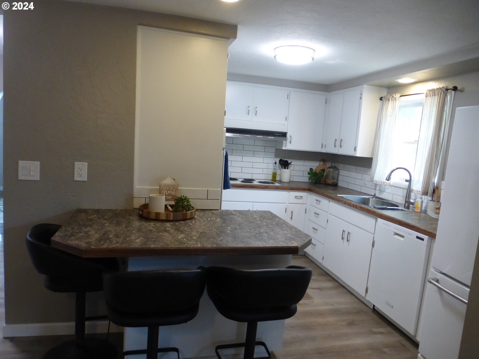 1026 M Street Springfield, OR 97477 - Photo 7 of 20 a kitchen with stainless steel appliances granite countertop a sink refrigerator and cabinets