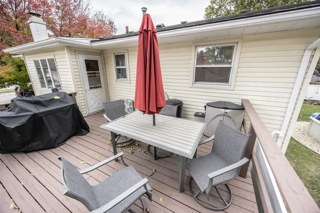 a view of a patio with table and chairs with wooden floor and fence