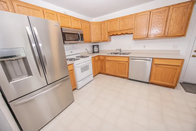 a kitchen with stainless steel appliances granite countertop a refrigerator sink and stove