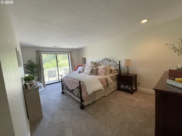 a bedroom with a bed a table and a flat screen tv