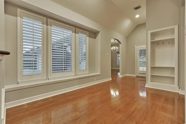 a spacious bedroom with a bed a couch and large windows