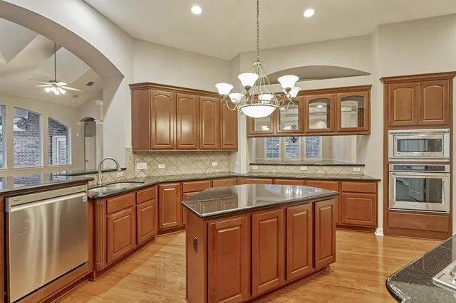 a kitchen with stainless steel appliances granite countertop a stove a sink and a refrigerator