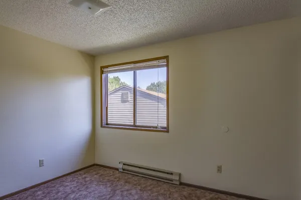 an empty room with a fireplace and wooden floor