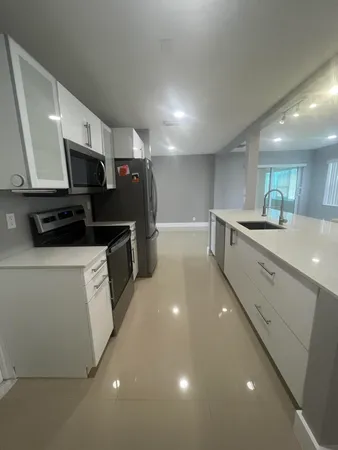 a kitchen with stainless steel appliances a refrigerator sink and microwave
