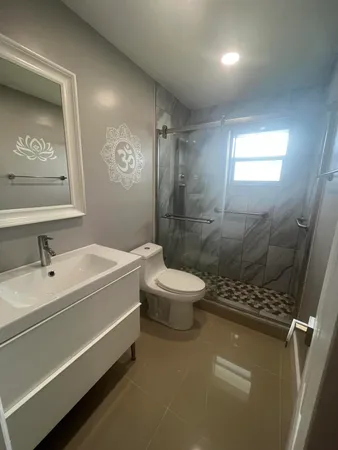 a bathroom with a sink a toilet and shower