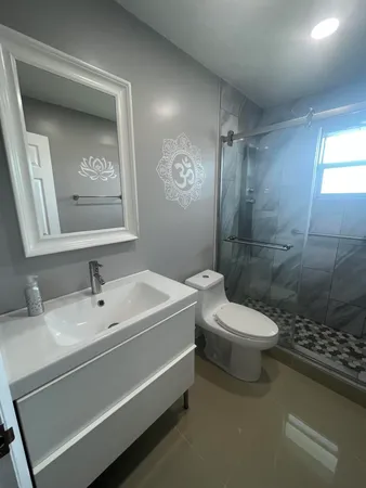 a bathroom with a sink a toilet and shower