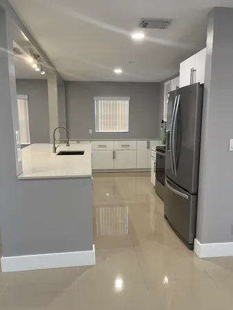 a kitchen with stainless steel appliances granite countertop a refrigerator and a sink