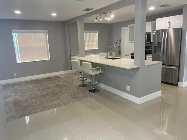 a room with table chairs and refrigerator