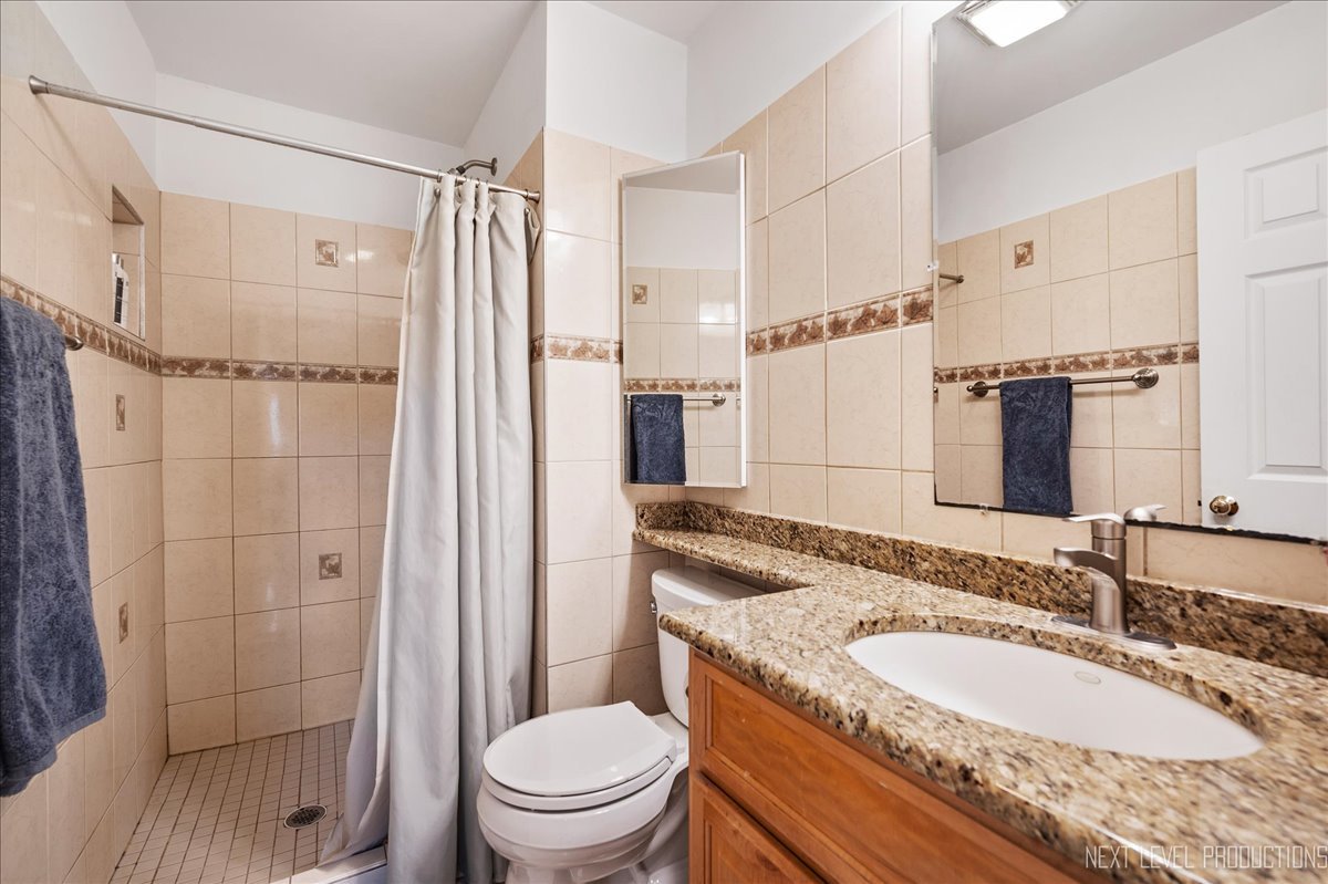 4N636 Klein Road West Chicago, IL 60185 - Photo 14 of 36 a bathroom with a granite countertop sink toilet mirror and shower