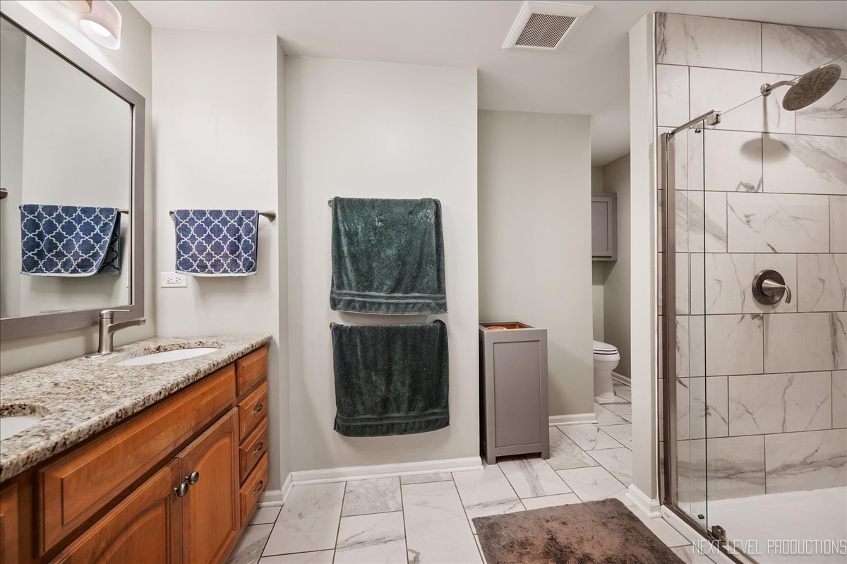 4N636 Klein Road West Chicago, IL 60185 - Photo 18 of 36 a bathroom with a granite countertop sink a toilet and shower