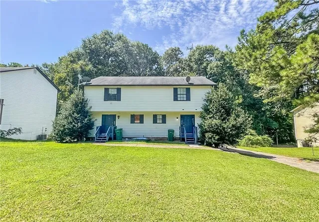 a view of a house with a yard and sitting area