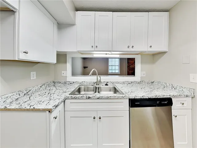 a kitchen with stainless steel appliances granite countertop a sink and cabinets