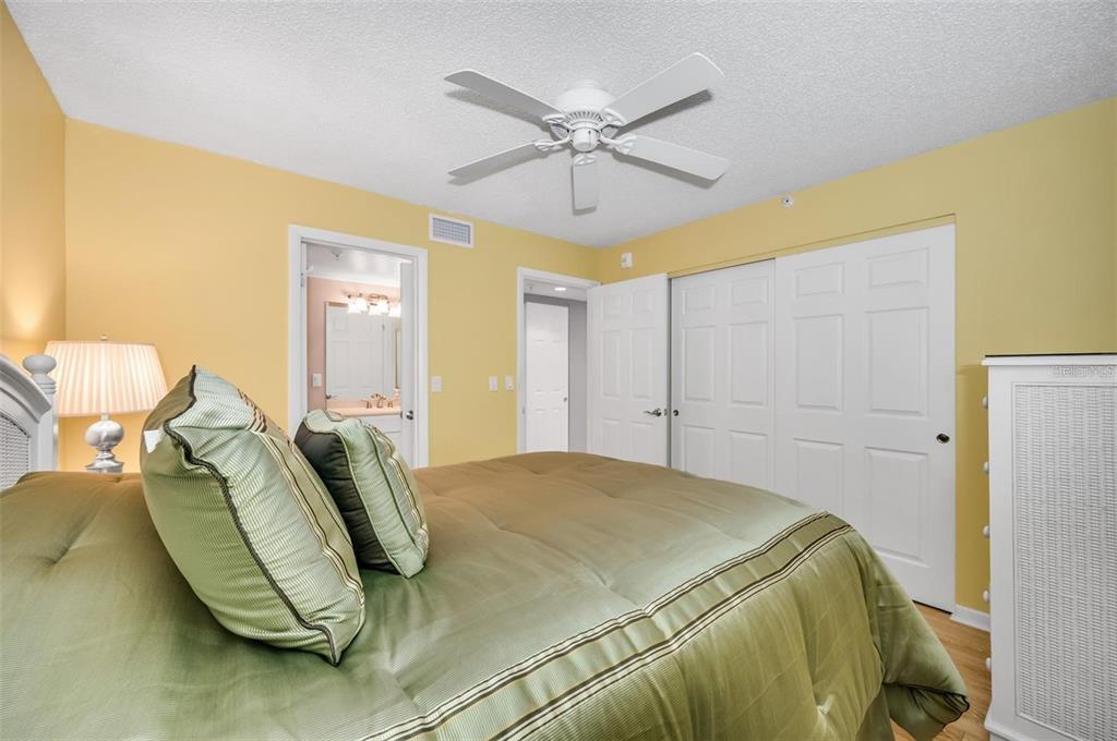 12924 Gulf Boulevard, Unit 510 Madeira Beach, FL 33708 - Photo 42 of 61 a bedroom with a bed and a ceiling fan