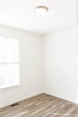 a view of a small space with wooden floor and a window