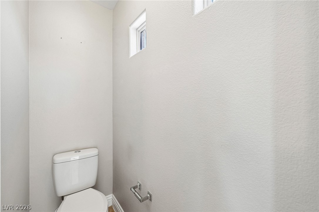 1176 Butternut Ranch Court Henderson, NV 89052 - Photo 37 of 60 A well-appointed powder room features a functional toilet and elegant small windows.