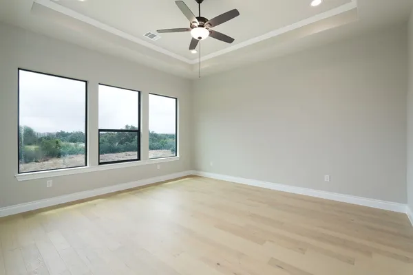 an empty room with a window and a ceiling fan