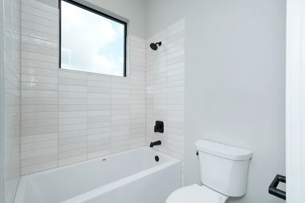 a bathroom with a toilet bathtub and window