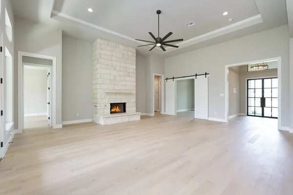 an empty room with windows and fireplace