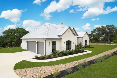 a front view of a house with a garden and yard