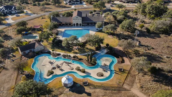 an aerial view of residential house with yard and swimming pool