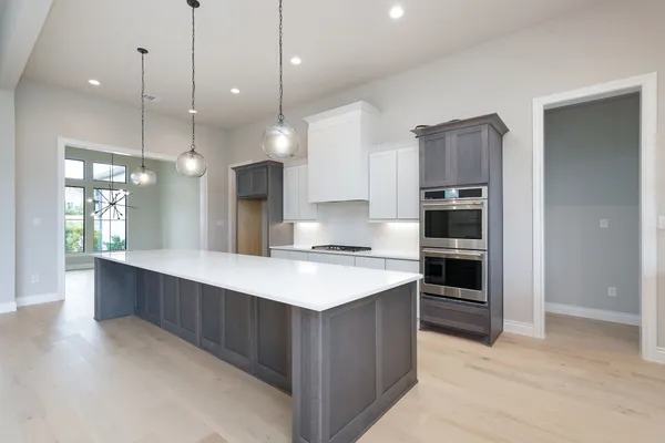a kitchen with kitchen island a sink stainless steel appliances and cabinets