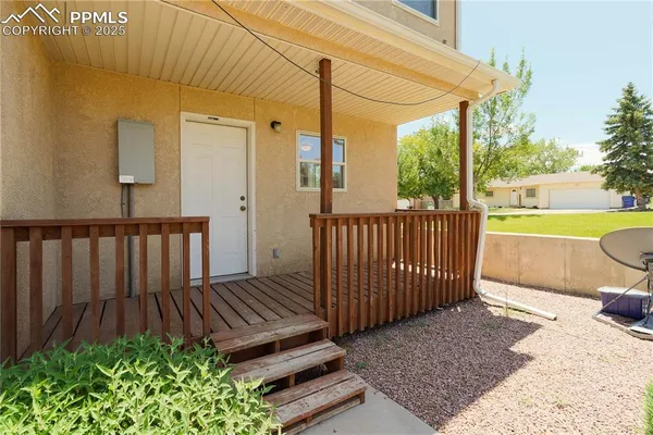 a view of a backyard with wooden floor and fence