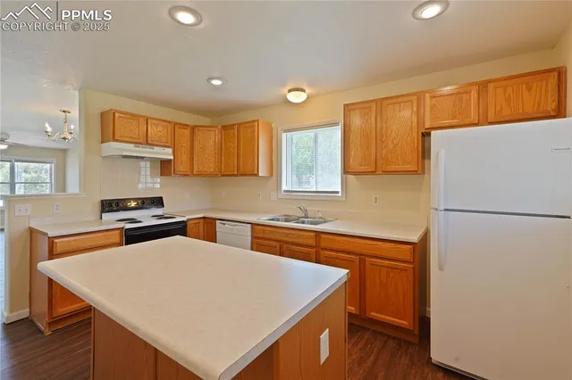 a kitchen with stainless steel appliances a refrigerator a sink a stove a microwave a center island and a counter space