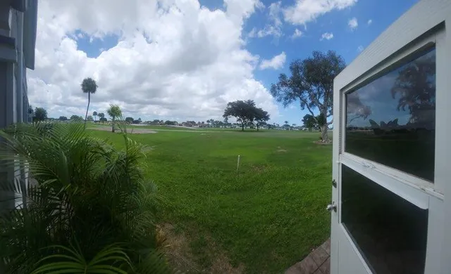 a view of a green field with wooden fence