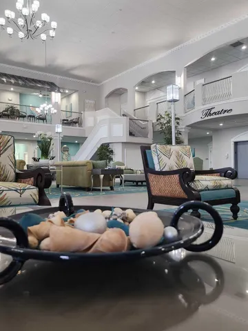 a living room with furniture a chandelier and a large mirror