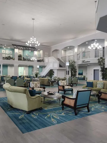 a living room with fireplace furniture and a chandelier