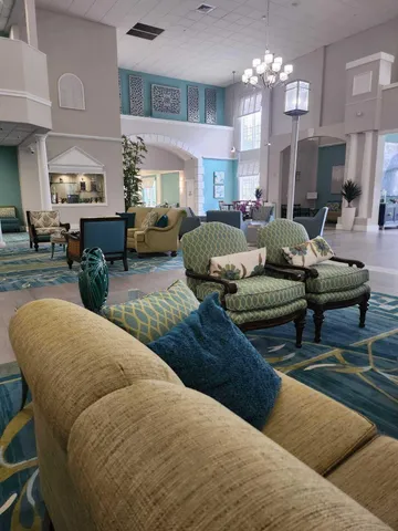 a living room with furniture chandelier and view of kitchen