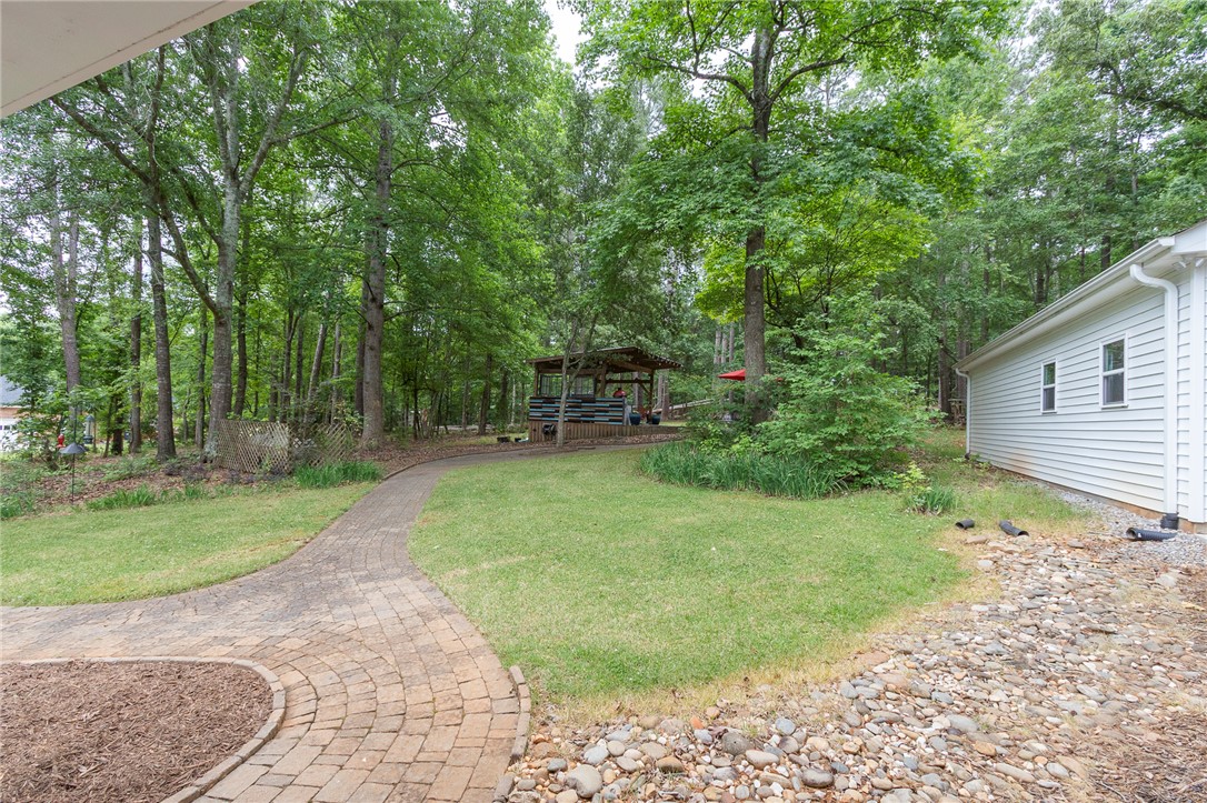 203 Oak Hollow Pendleton, SC 29670 - Photo 38 of 50 A winding paved pathway leads through a private, verdant backyard with a charming gazebo.