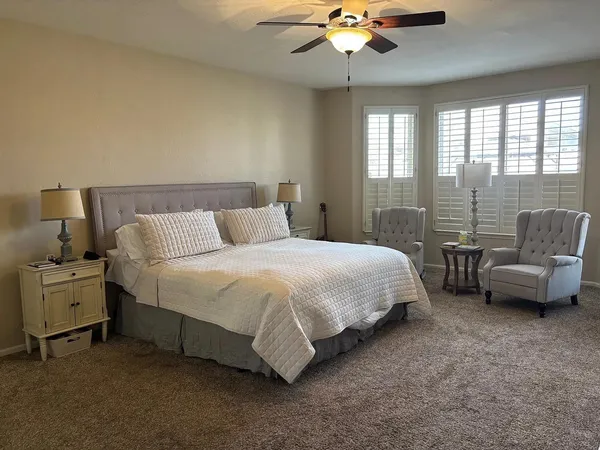 a spacious bedroom with a bed and a chandelier