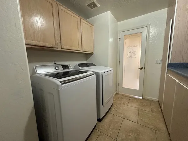 a utility room with cabinets washer and dryer