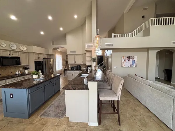 a large kitchen with stainless steel appliances kitchen island granite countertop a large island in the center