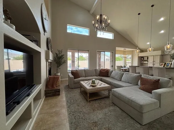 a living room with furniture a chandelier and a flat screen tv