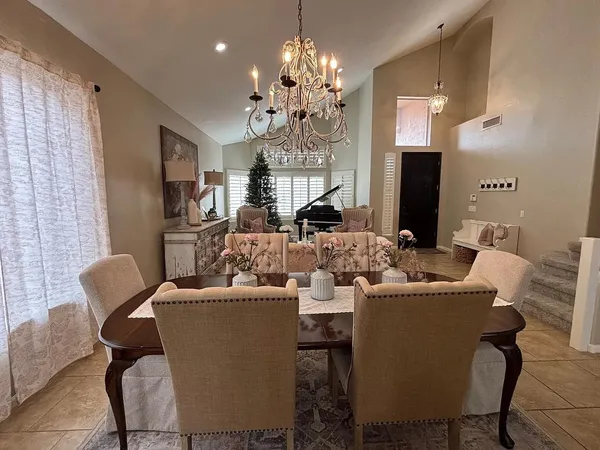 a dining room with furniture a chandelier and window