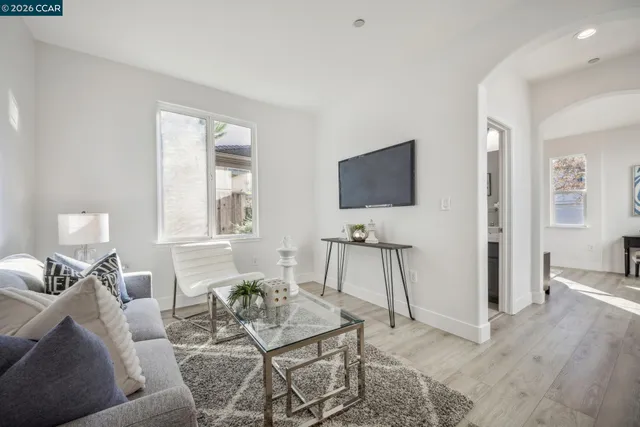 a living room with furniture and a wooden floor