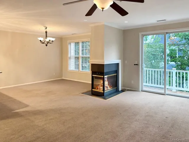 an empty room with windows and ceiling fan