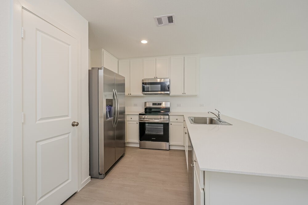 621 Craven Street Conroe, TX 77316 - Photo 6 of 16 a kitchen with a refrigerator and a stove top oven
