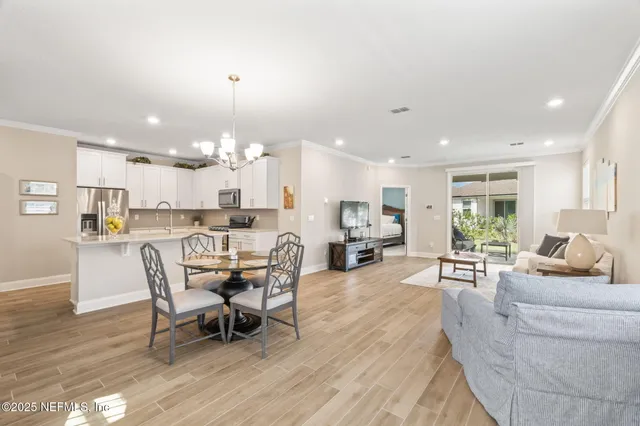 a view of a dining room with furniture a chandelier and wooden floor
