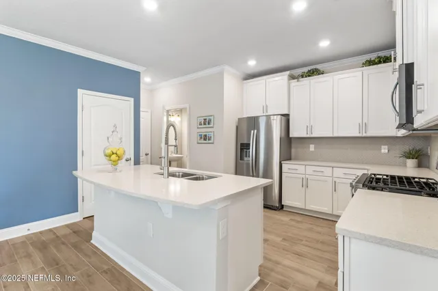 a kitchen with a sink stainless steel appliances and white cabinets