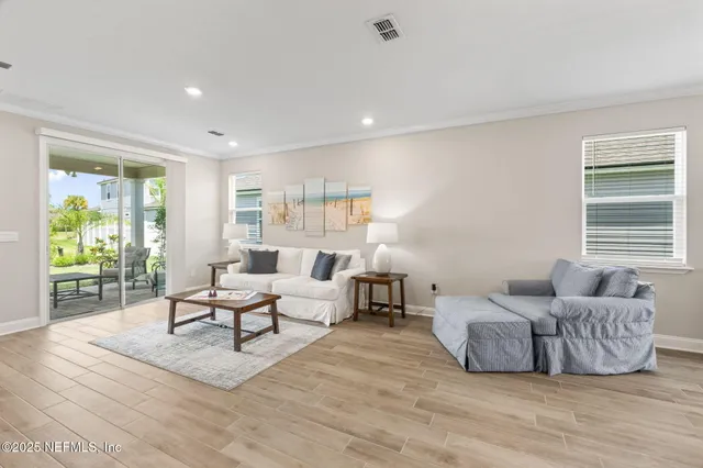 a living room with furniture and a flat screen tv with wooden floor